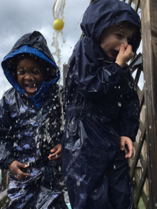 Photo of Nursery pupils playing with water outdoors.